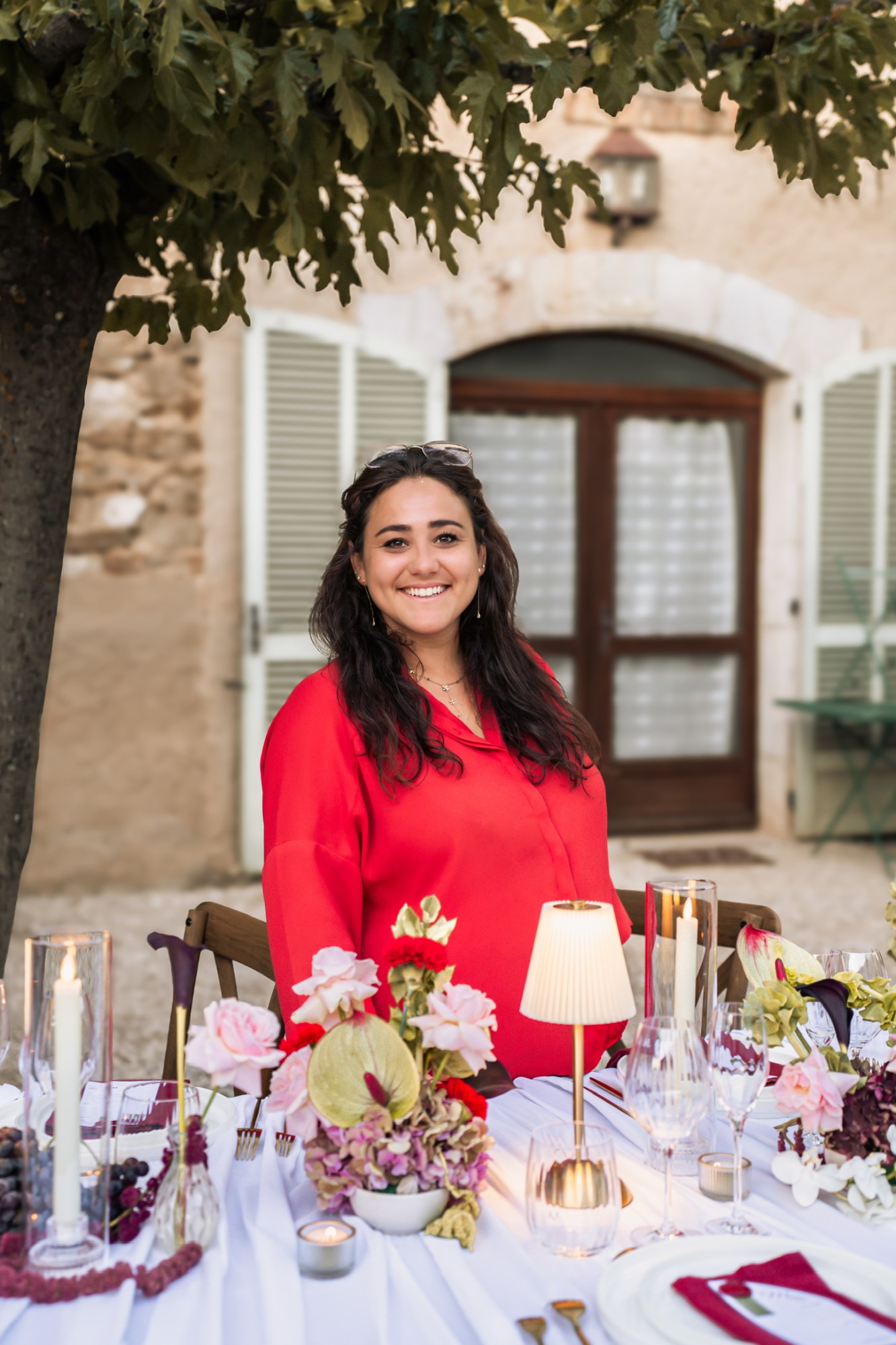 Océane, décoratrice de mariage en Provence, souriante devant sa table de mariage fleurie aux Terres Saint-Hilaire — Décore tes rêves