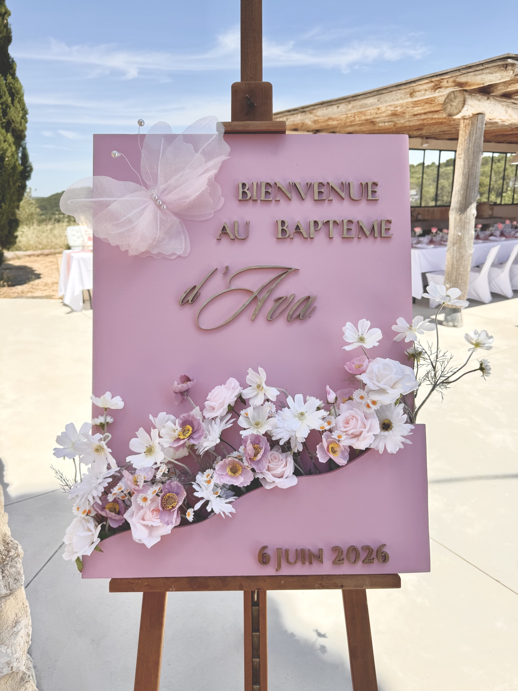 Panneau de bienvenue du baptême d'Ava fleuri rose et doré avec papillon en organza — Décore tes rêves