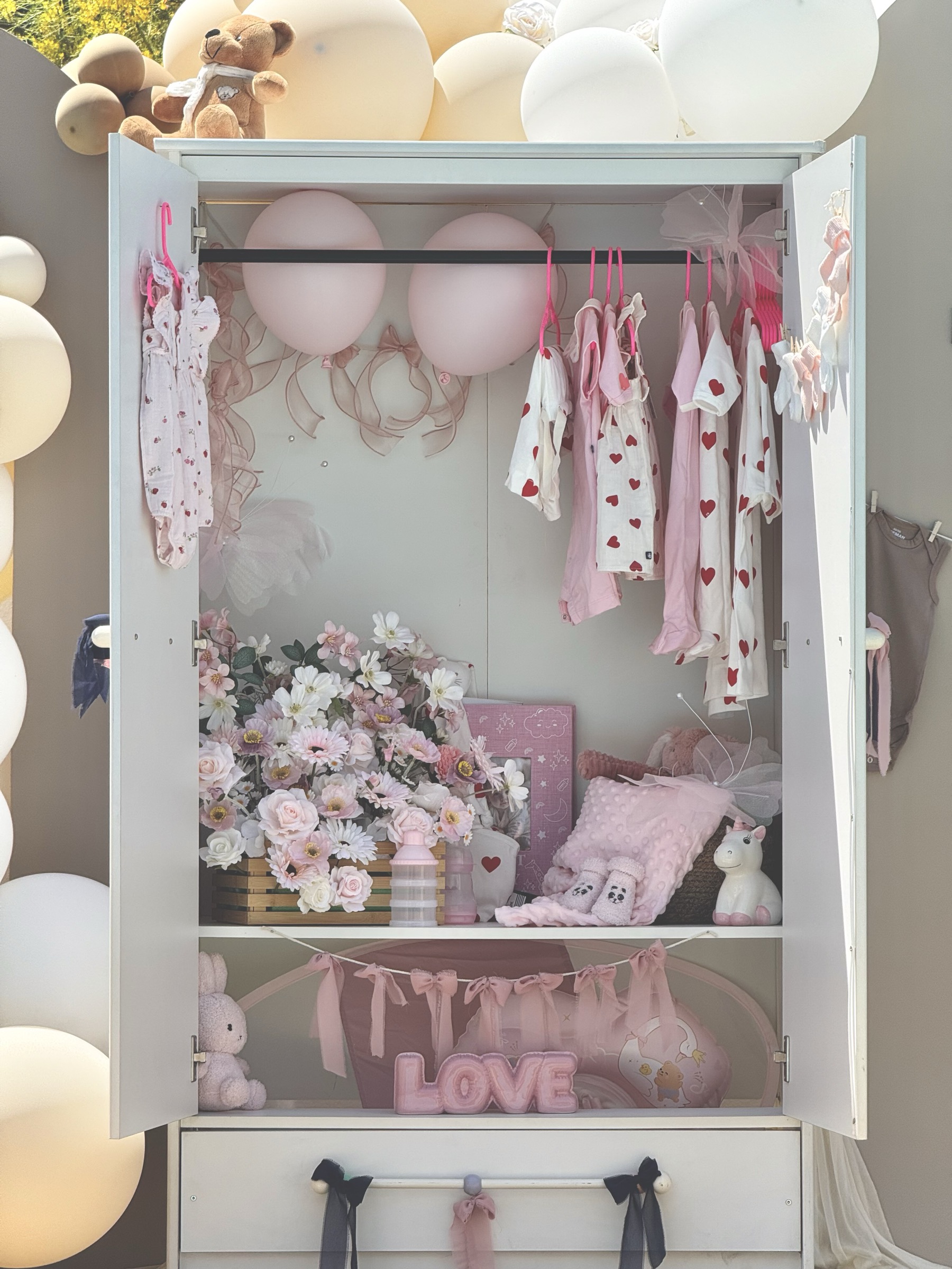 Armoire de gender reveal ouverte révélant les vêtements roses et la décoration fille — Décore tes rêves Provence