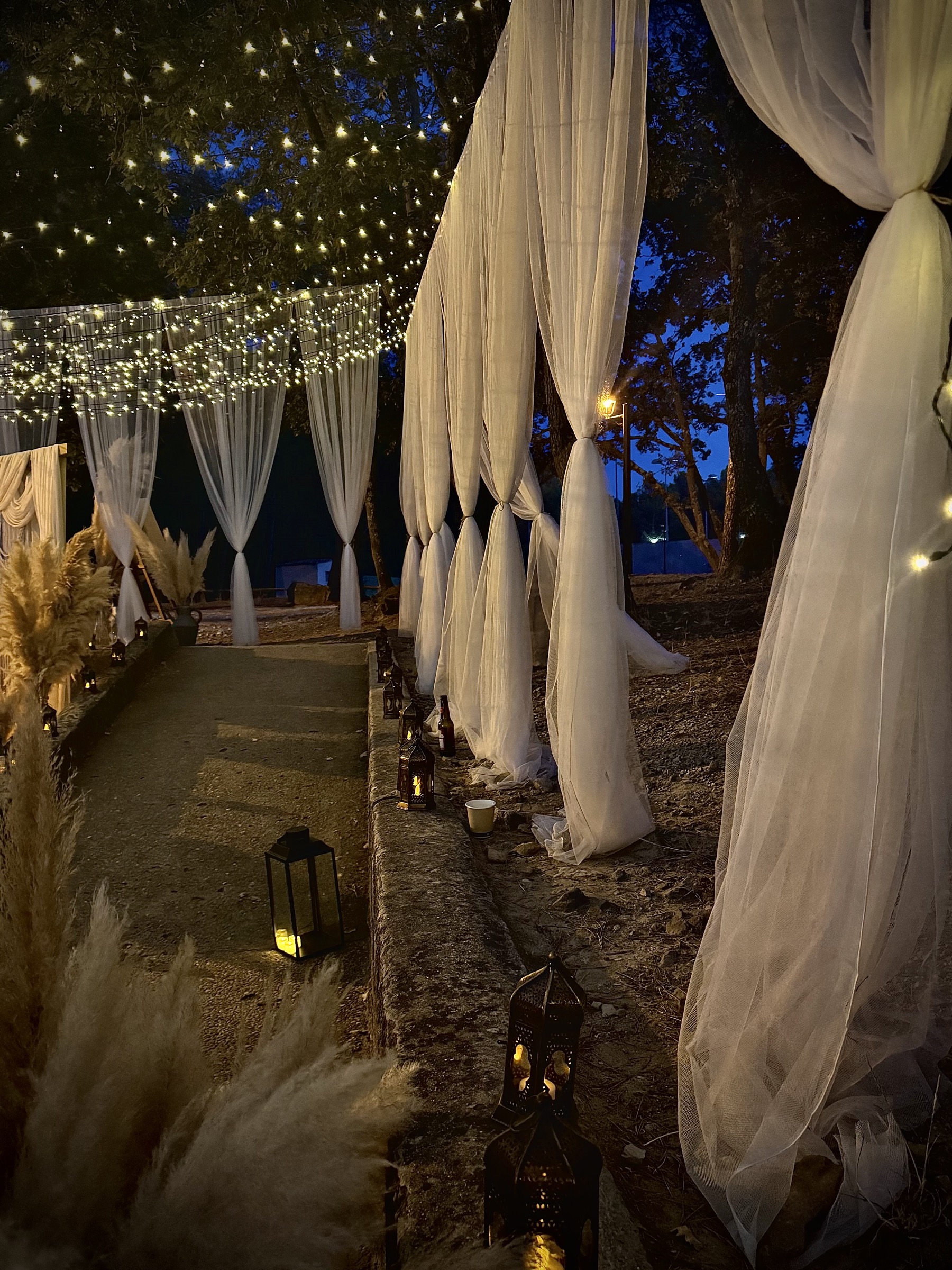 Allée de mariage de nuit avec guirlandes lumineuses et lanternes marocaines — ambiance bohème en Provence