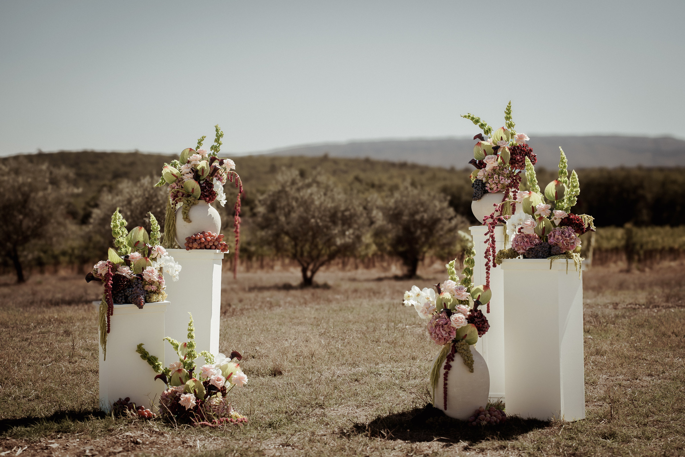 Colonnes fleuries de cérémonie laïque devant les oliviers — décoration de mariage en Provence