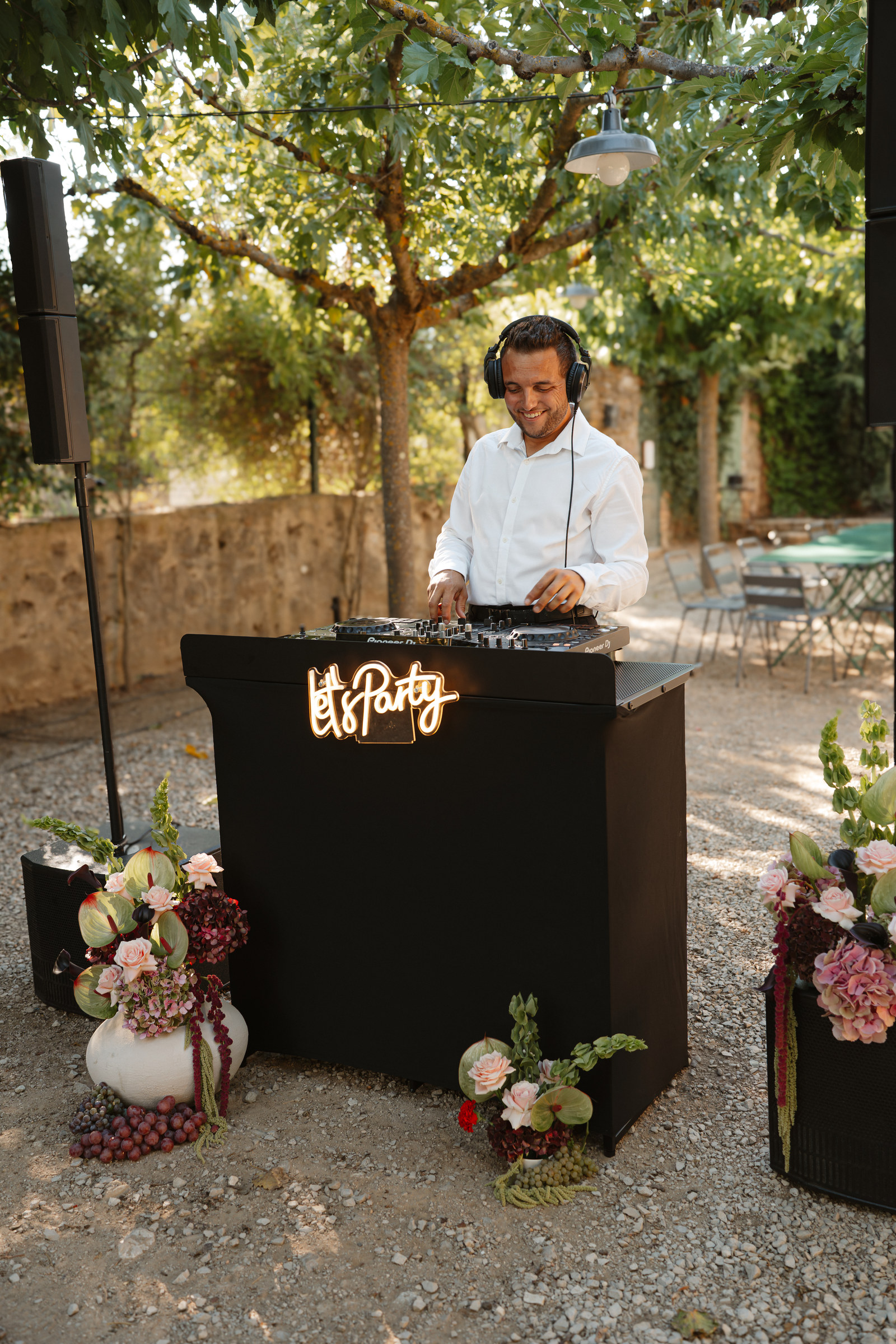 Espace DJ de mariage décoré de compositions florales et de raisin