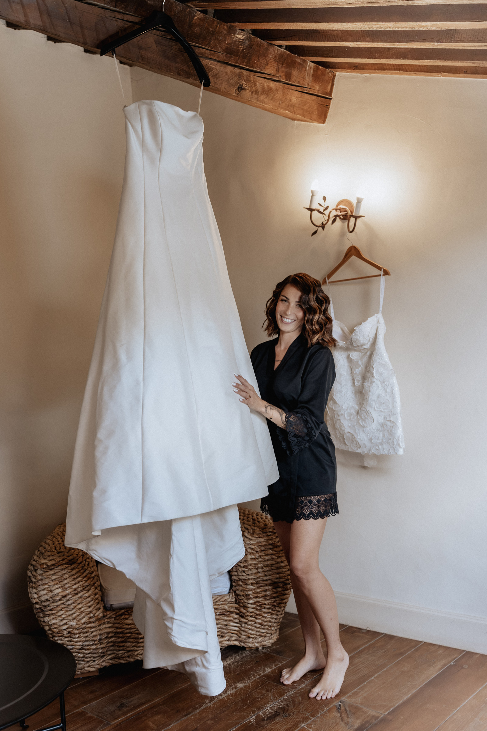 Préparatifs de la mariée à côté de sa robe suspendue, chambre du domaine des Terres Saint-Hilaire