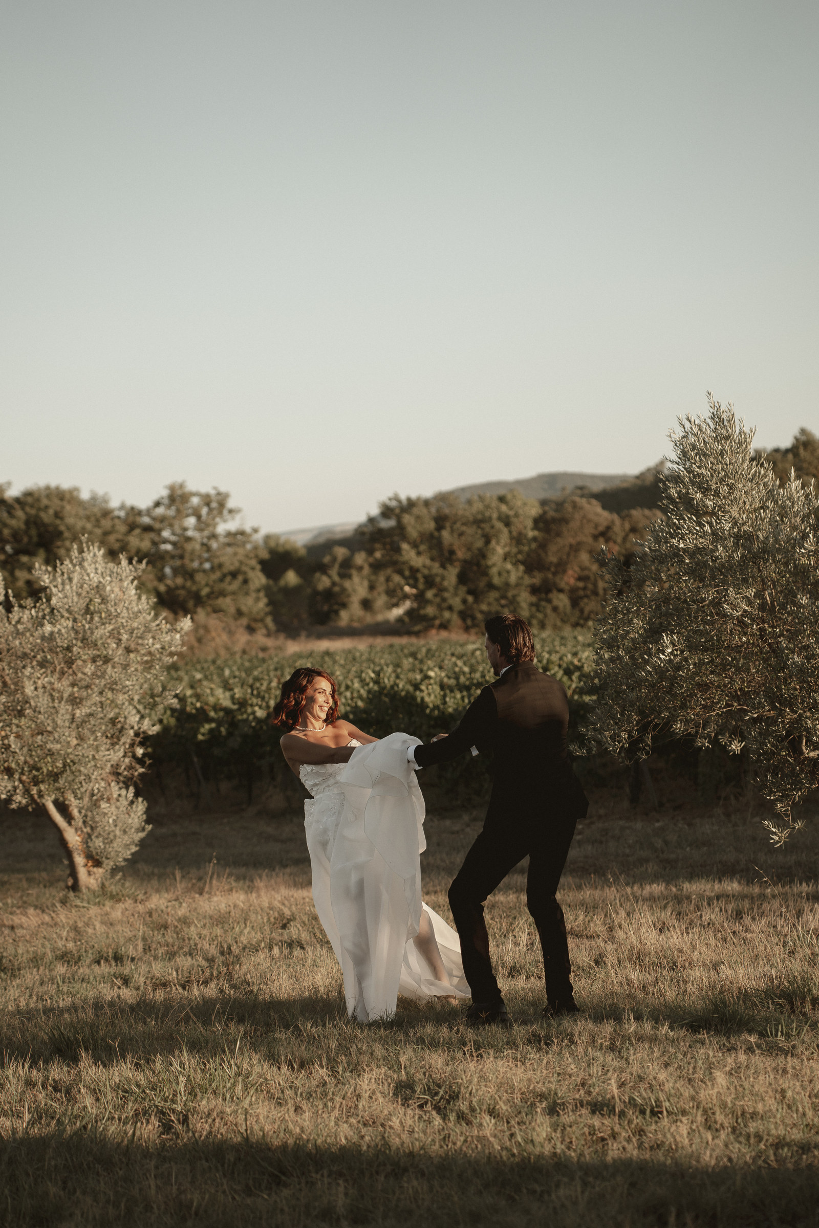 Mariés courant dans le champ, robe au vent, shooting Vendanges Chic en Provence