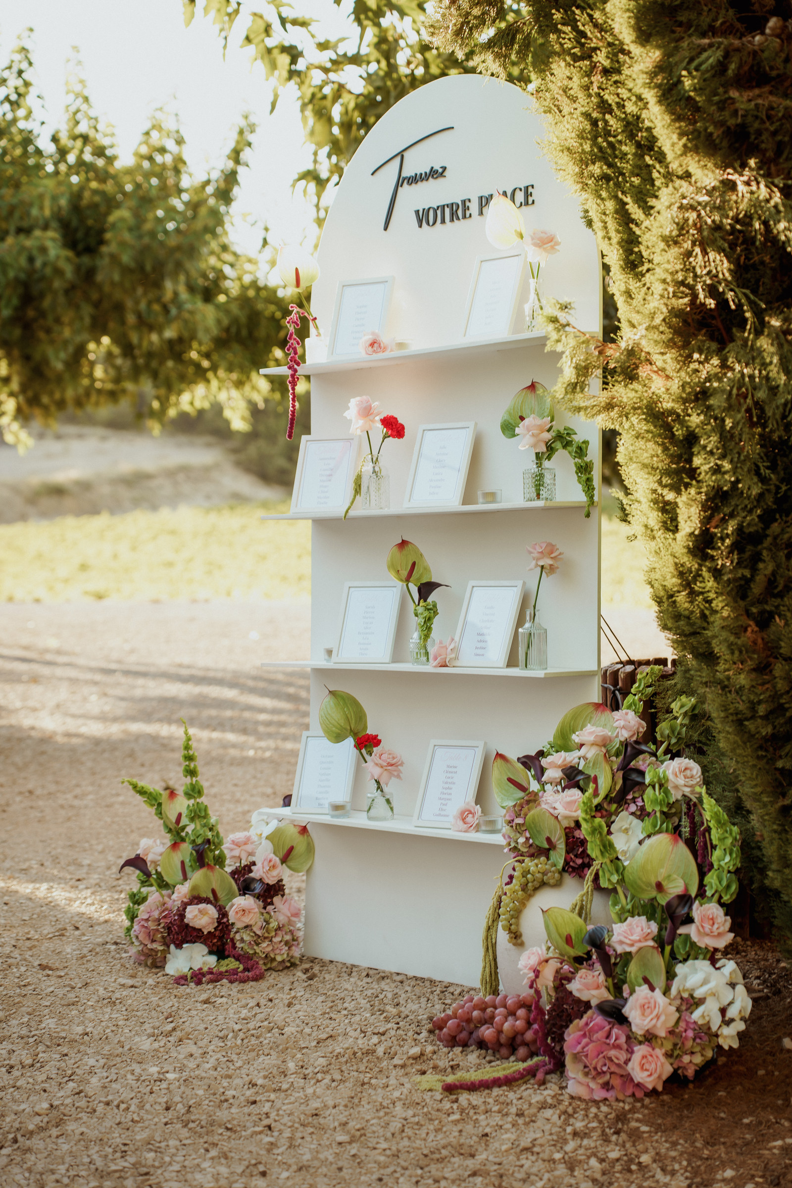 Plan de table de mariage « Trouvez votre place » fleuri d'anthuriums, roses et amarante